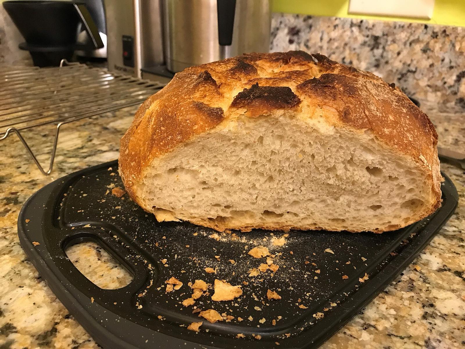A sourdough loaf cut open to show an open, airy crumb